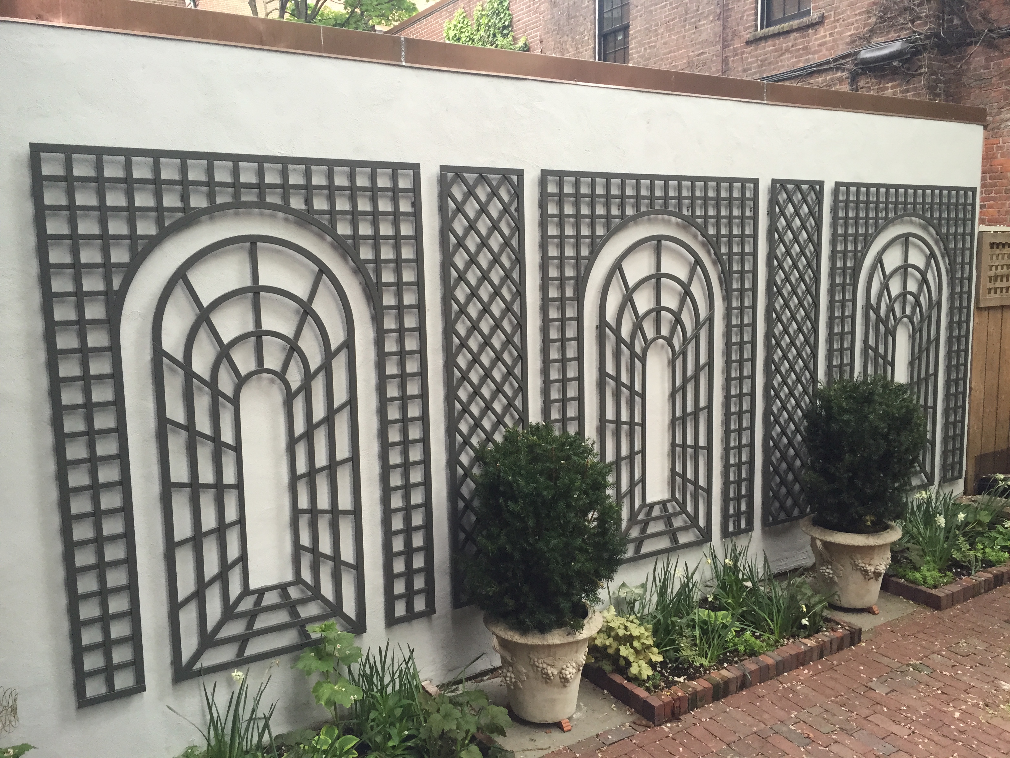 Courtyard wall with arched steel trellises